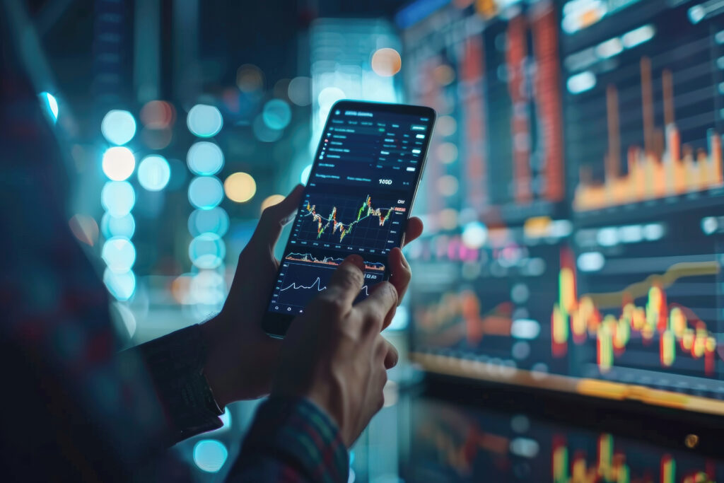 Businessman is holding a smartphone and checking stock and cryptocurrency markets - ForexMag.cz Jak vydělat 5000 Kč
investice