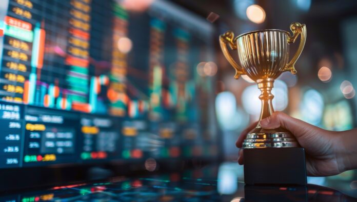 Golden trophy award in front of stock market or forex trading charts on computer screen Concept of financial success investment and wealth