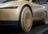 Tesla zahájila výrobu samořízených vozů taxi Cybercab, uvedl Musk Close-up of a gold car's front wheel with a smooth disk cover and black tire, low-angle view