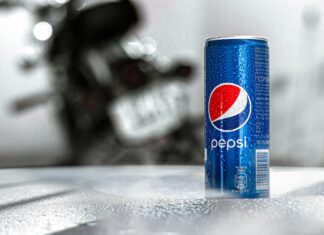 Nápojový kolos PepsiCo zvýšil čtvrtletní zisk, u růstu tržeb překonal odhady Blue Pepsi can with condensation on a textured table; a blurred motorcycle is in the background.