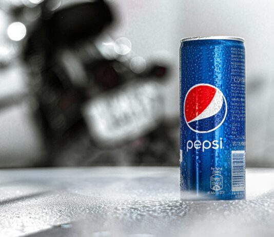 Nápojový kolos PepsiCo zvýšil čtvrtletní zisk, u růstu tržeb překonal odhady Blue Pepsi can with condensation on a textured table; a blurred motorcycle is in the background.